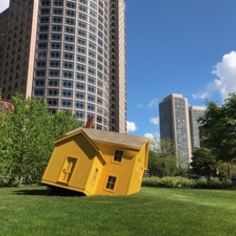 A yellow shed tilts off the ground in Boston's Greenway park.