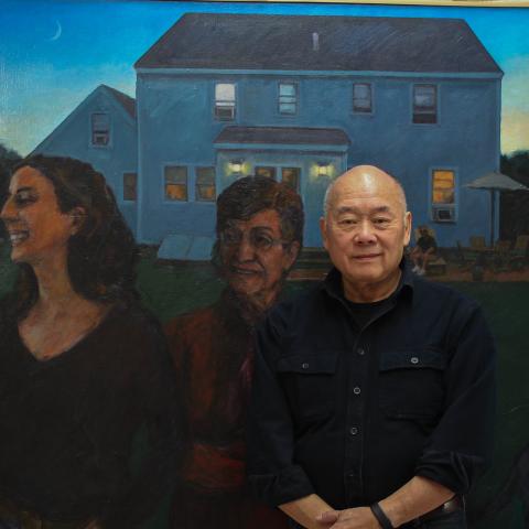 Wen-ti poses in front of one of his painting. A painting of women in the yard of a house at twilight.