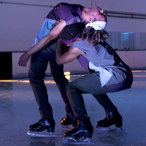 A Black ice skater leans over the back of another Black ice skater.